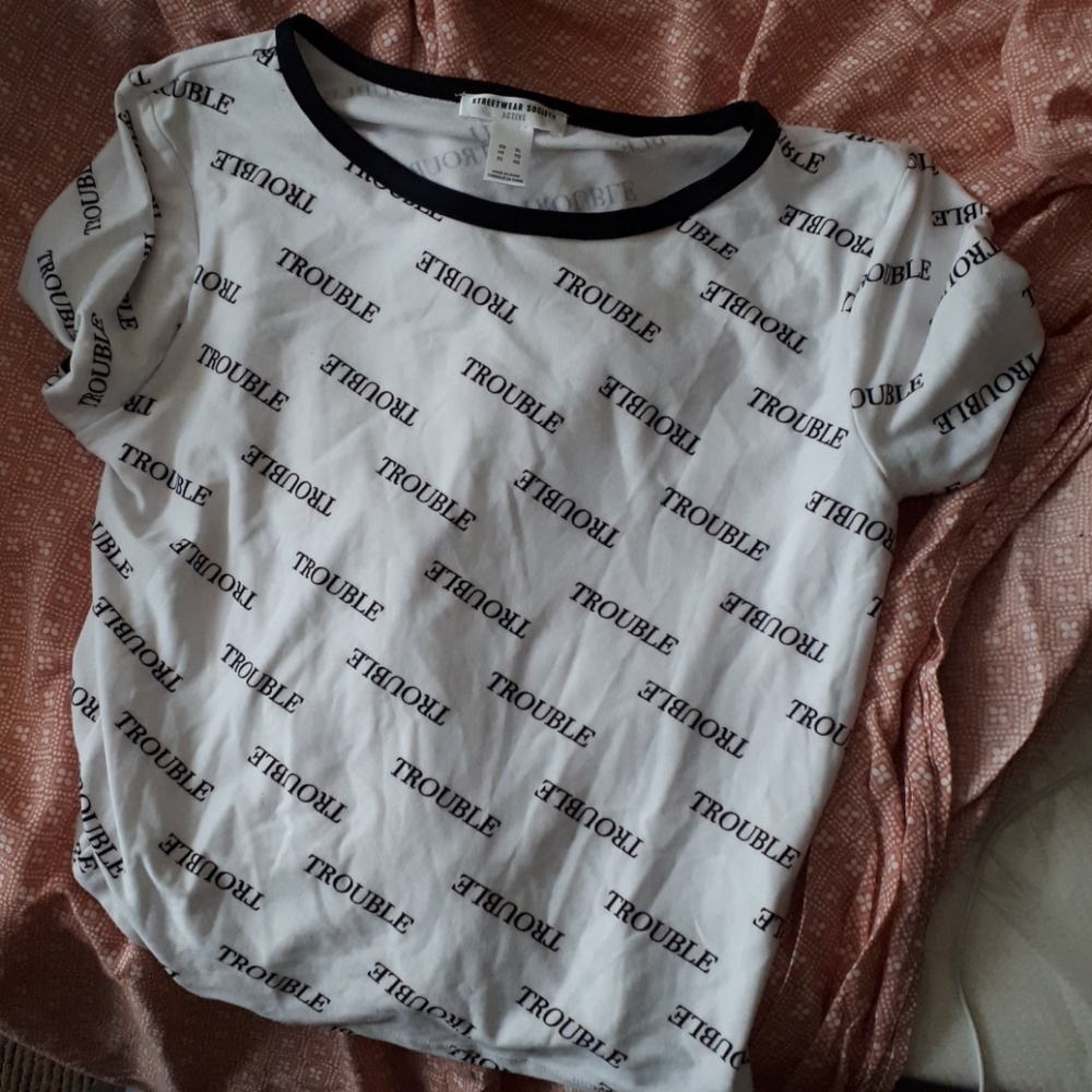 A shirt that has the word trouble, and black pants